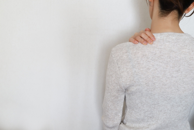 肩に手をあてる女性の後ろ姿
