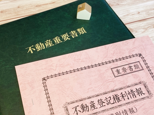 不動産の重要書類と家のミニチュア