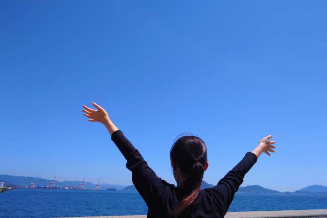 空に両手を広げる女性