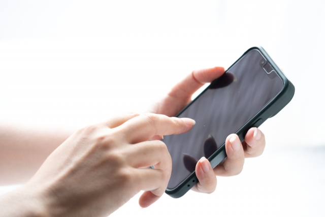 スマートフォンの画面を操作する手