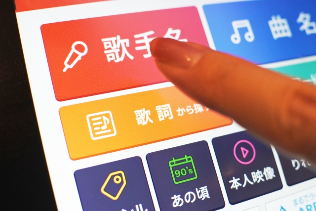 カラオケのリモコンで曲を選ぶ指