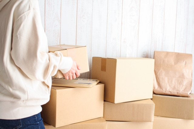 段ボールを運んで荷造りをする女性