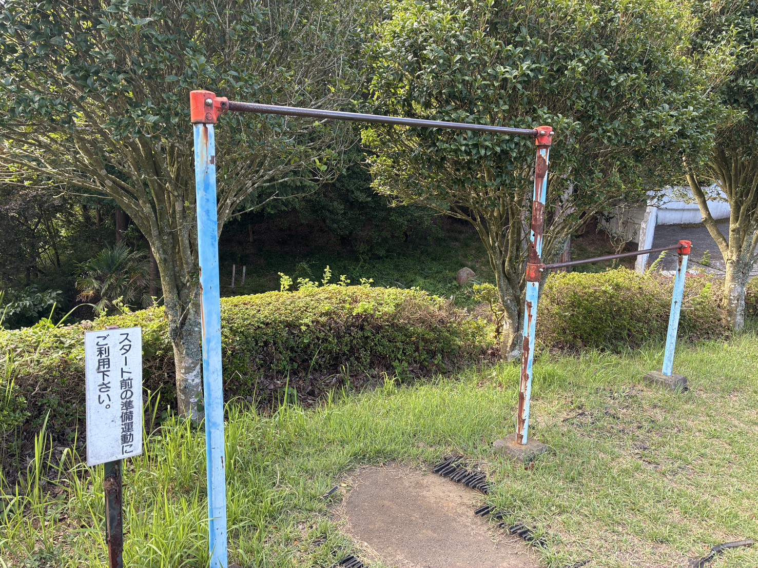 アウト1番ホール横の鉄棒と「スタート前の準備運動にご利用下さい」の看板