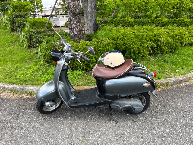 生垣のそばに停めてあるスクーターとヘルメット